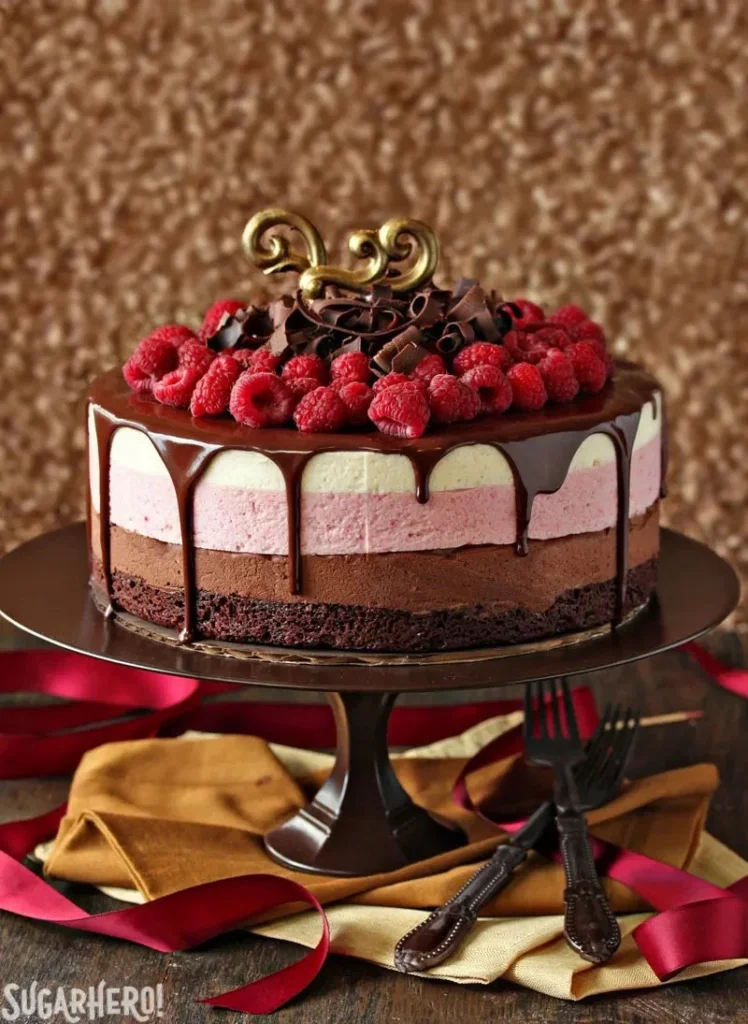 Chocolate raspberry mousse cake topped with fresh raspberries and chocolate shavings.