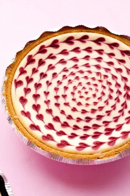 Delicious white chocolate raspberry cheesecake topped with fresh raspberries.