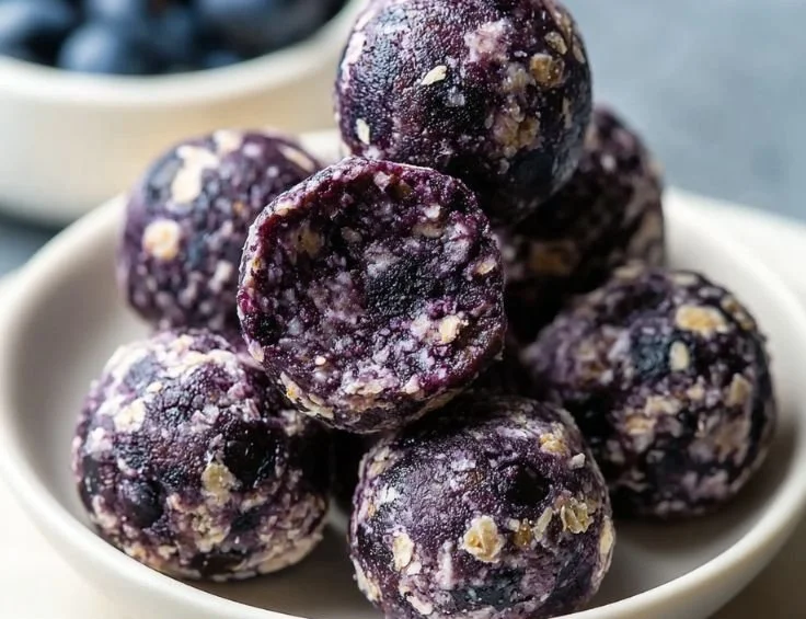 Homemade blueberry protein balls on a wooden surface
