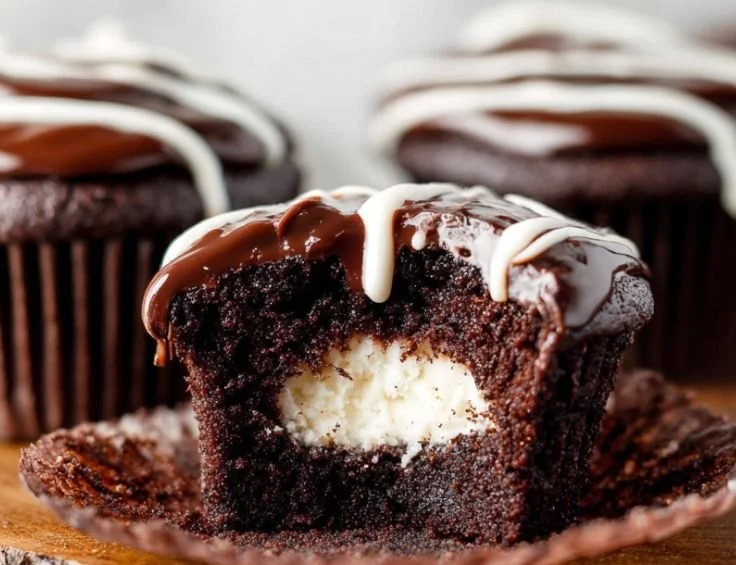 Cream-filled chocolate cupcakes topped with frosting and sprinkles
