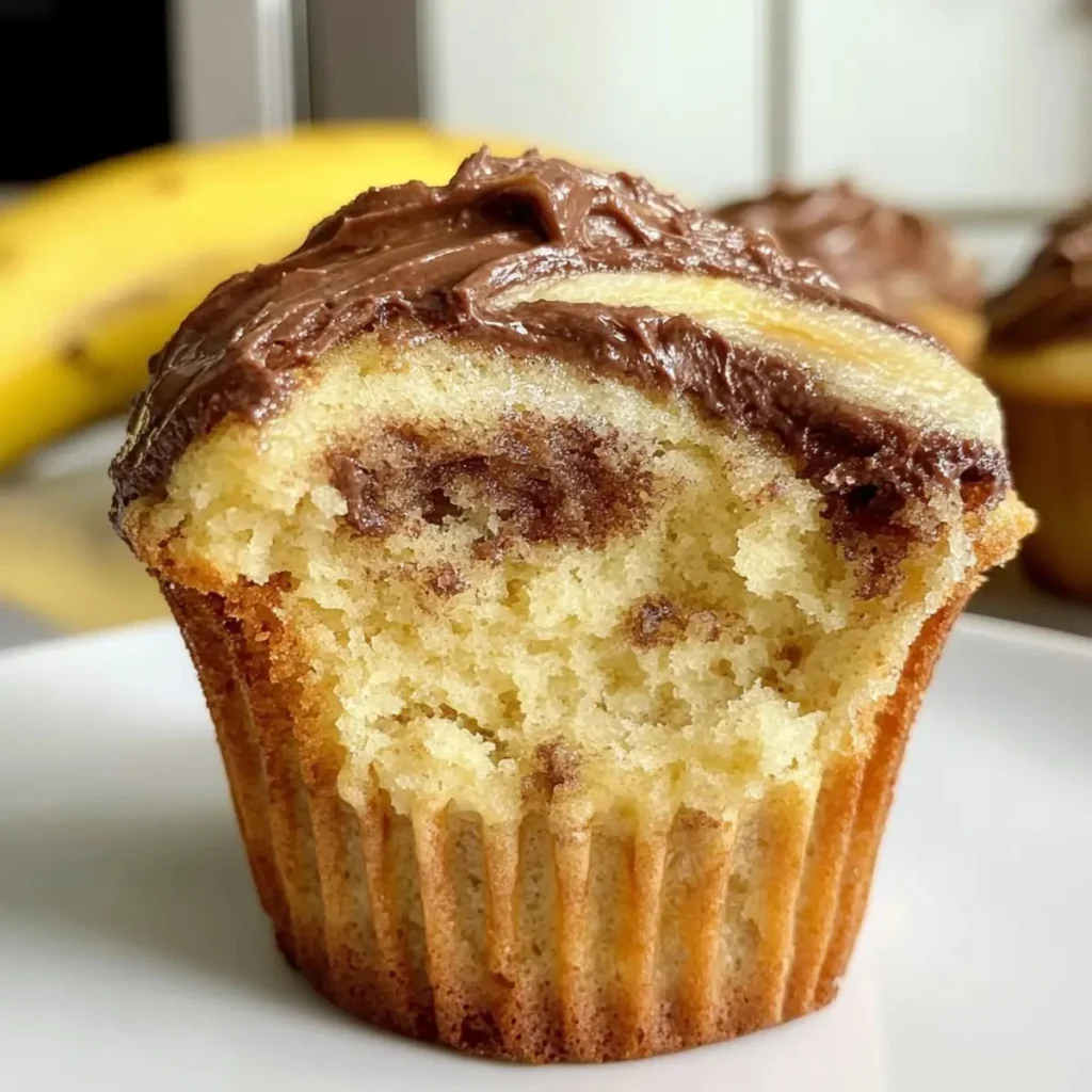 Nutella Swirl Banana Muffins topped with chocolate and banana slices