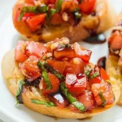Plate of authentic Italian Bruschetta topped with tomatoes and basil