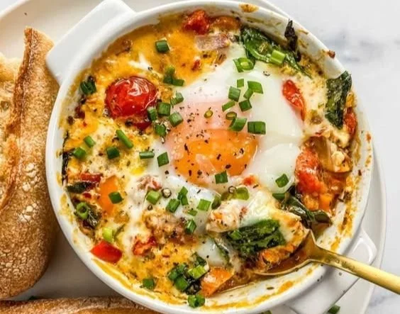 A delicious plate of baked feta eggs with herbs and vegetables.