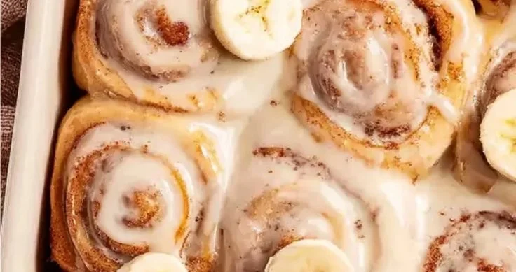 Freshly baked banana bread cinnamon rolls drizzled with icing