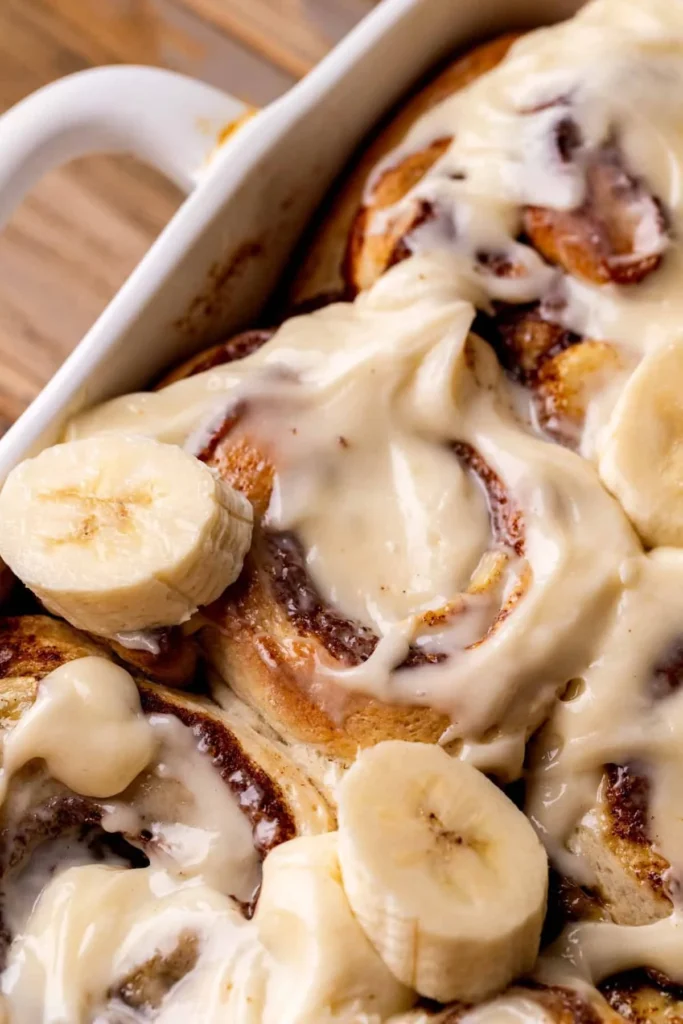 Freshly baked banana cinnamon rolls with a drizzle of icing on top