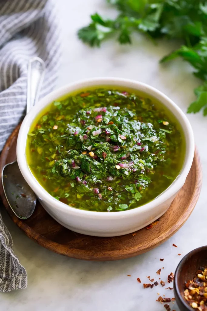 Fresh chimichurri sauce with herbs and spices served in a bowl.