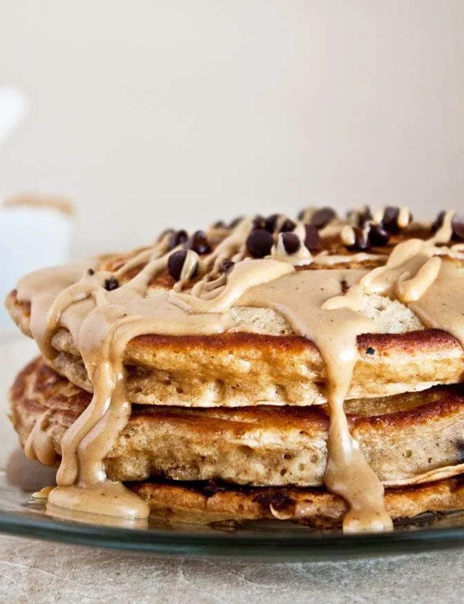 Delicious coffee pancakes stacked on a plate with syrup and coffee beans