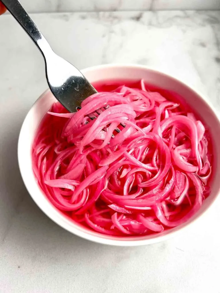 Spicy and vibrant pickled red onions in a glass jar