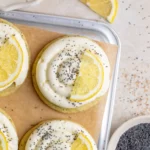Lemon poppy seed cheesecake cookie on a plate with a slice missing
