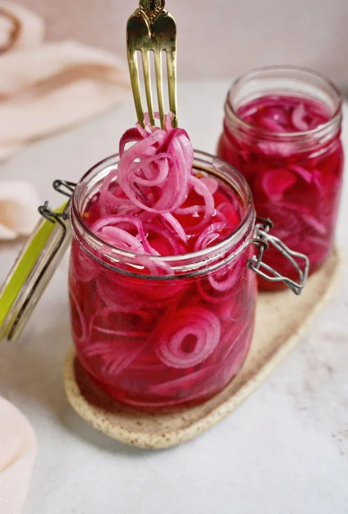 Jar of homemade pickled red onions on a kitchen countertop