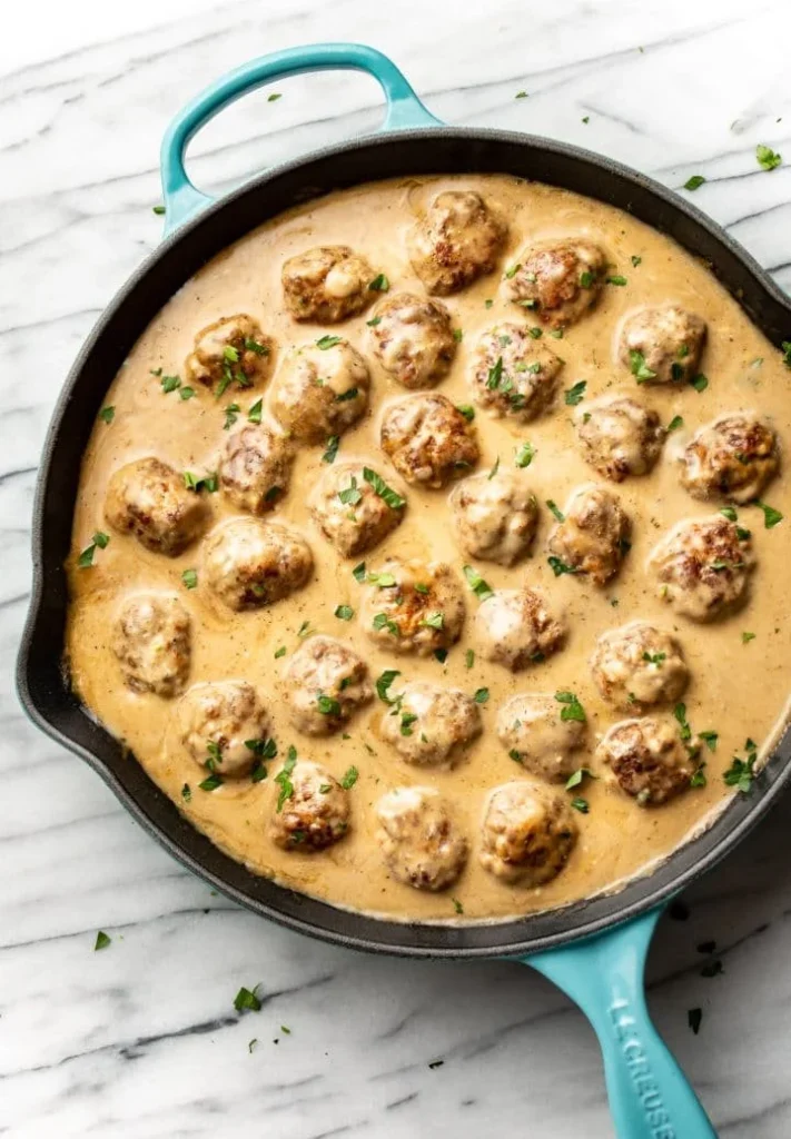 Delicious homemade Swedish Meatballs served with creamy sauce and lingonberry jam.