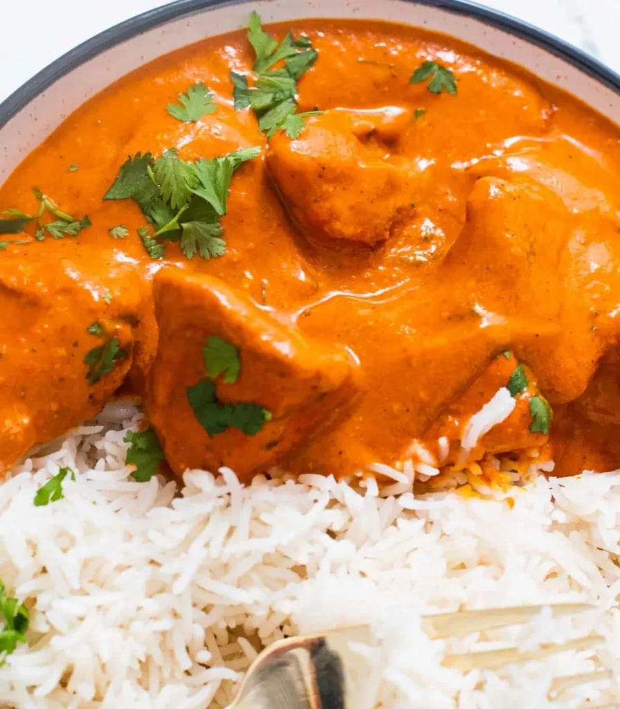Delicious butter chicken served with creamy sauce and rice.