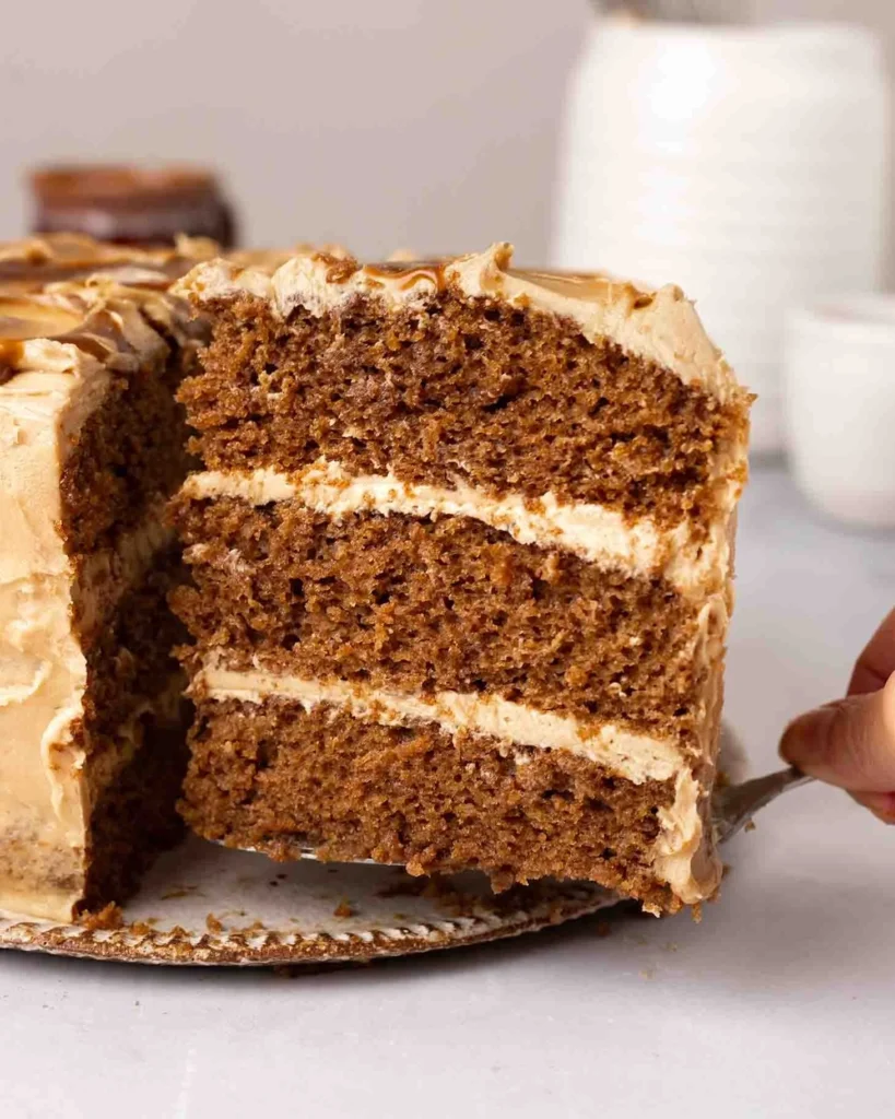 Delicious vegan espresso cake topped with coffee frosting and cocoa dust.
