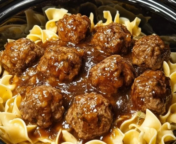 Amish meatball noodles served in a bowl with herbs