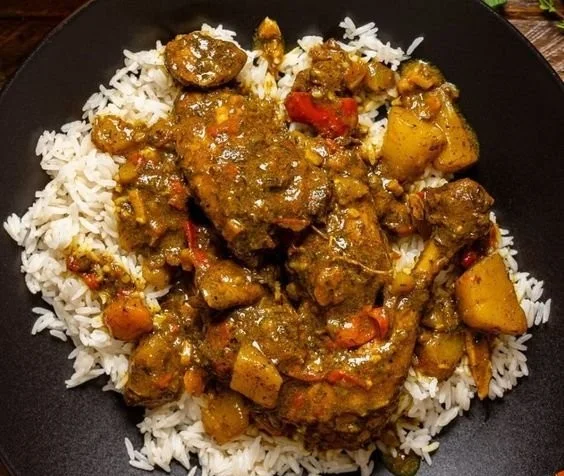 Delicious Jamaican Curry Chicken served with rice and vegetables