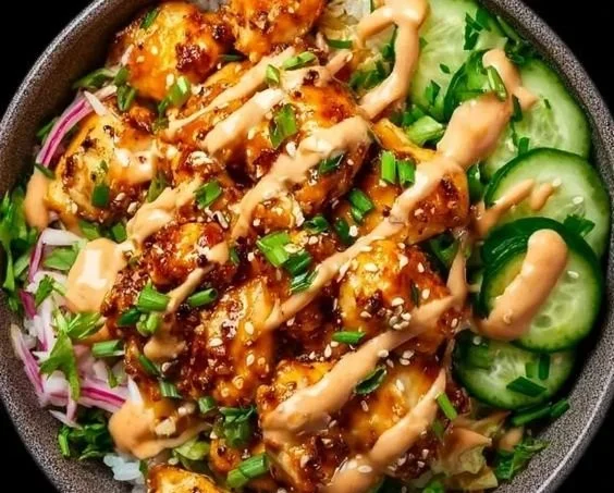 Delicious Bang Bang Chicken Bowl topped with creamy sauce and fresh veggies