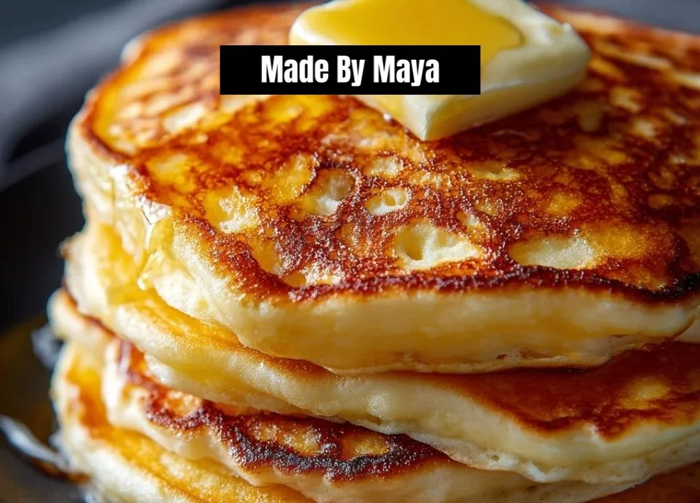 Stack of fluffy old fashioned pancakes topped with syrup and berries