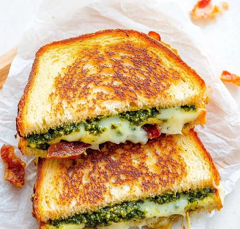 Delicious pesto grilled cheese sandwich with melted cheese and fresh basil pesto