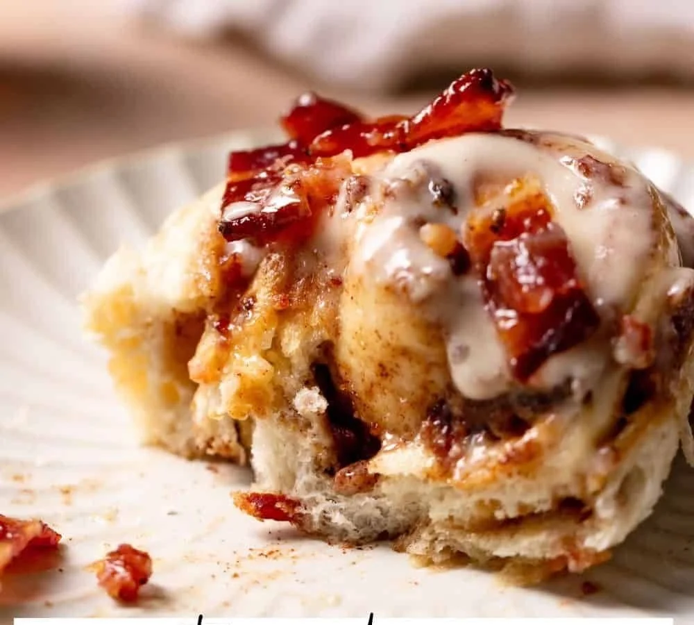 Bourbon Maple Bacon Cinnamon Rolls drizzled with glaze on a plate