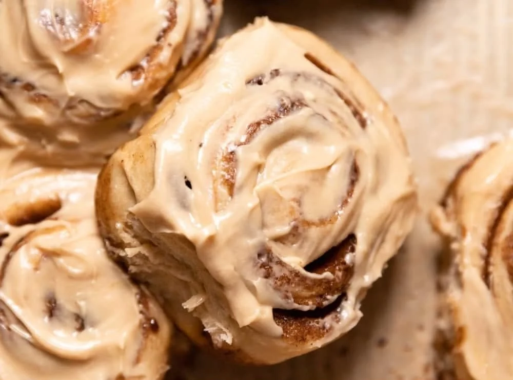 Freshly baked coffee cinnamon rolls topped with icing