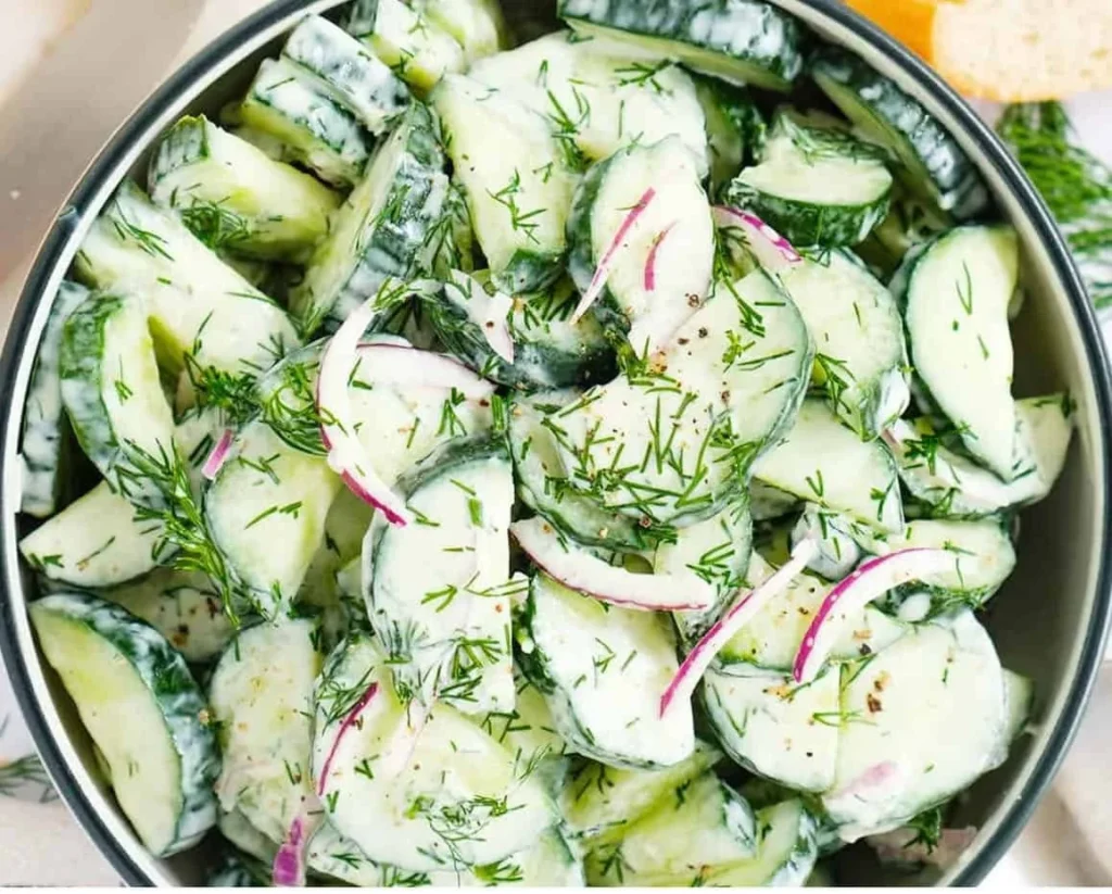 A bowl of fresh Cucumber Dill Salad garnished with dill sprigs.