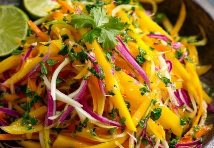 Bowl of delicious mango slaw with colorful vegetables