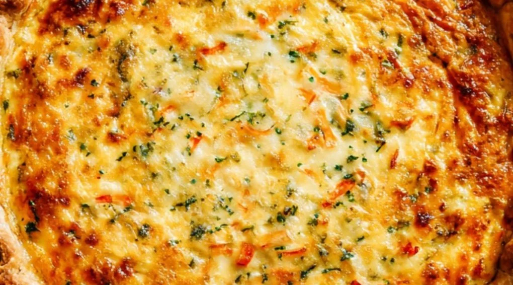 A slice of delicious quiche with fresh vegetables and cheese on a plate