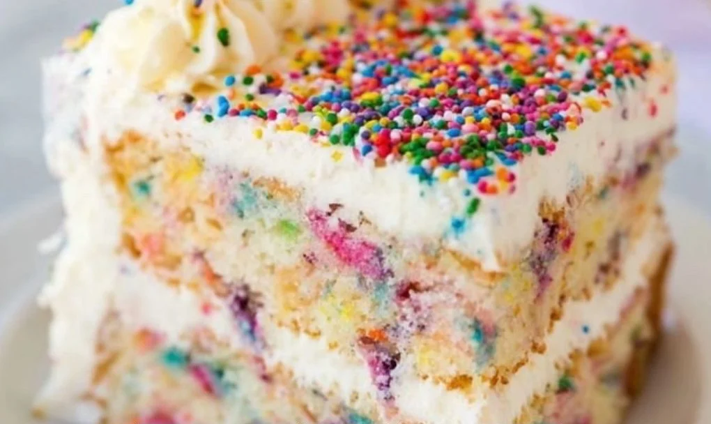 Slice of funfetti birthday cake topped with colorful sprinkles