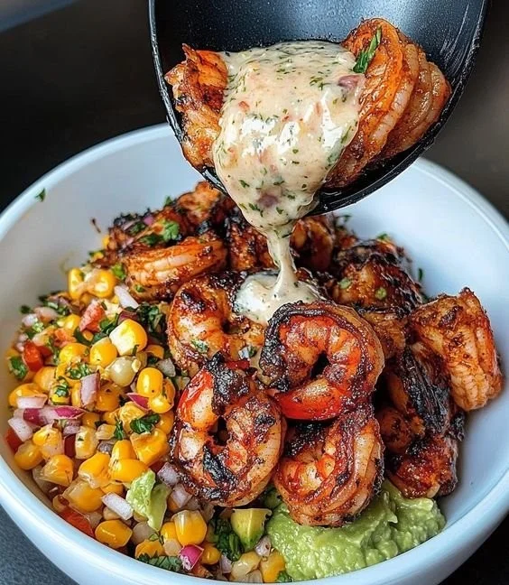 Grilled shrimp bowl with avocado, corn salsa, and creamy garlic sauce.