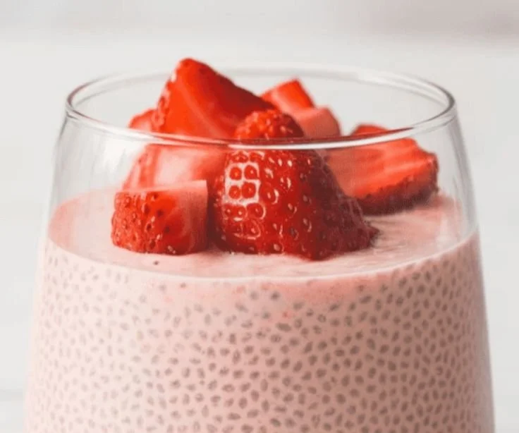 High-protein strawberry chia seed pudding in a glass topped with fresh strawberries.