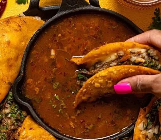 Delicious homemade birria tacos with rich broth and tender meat