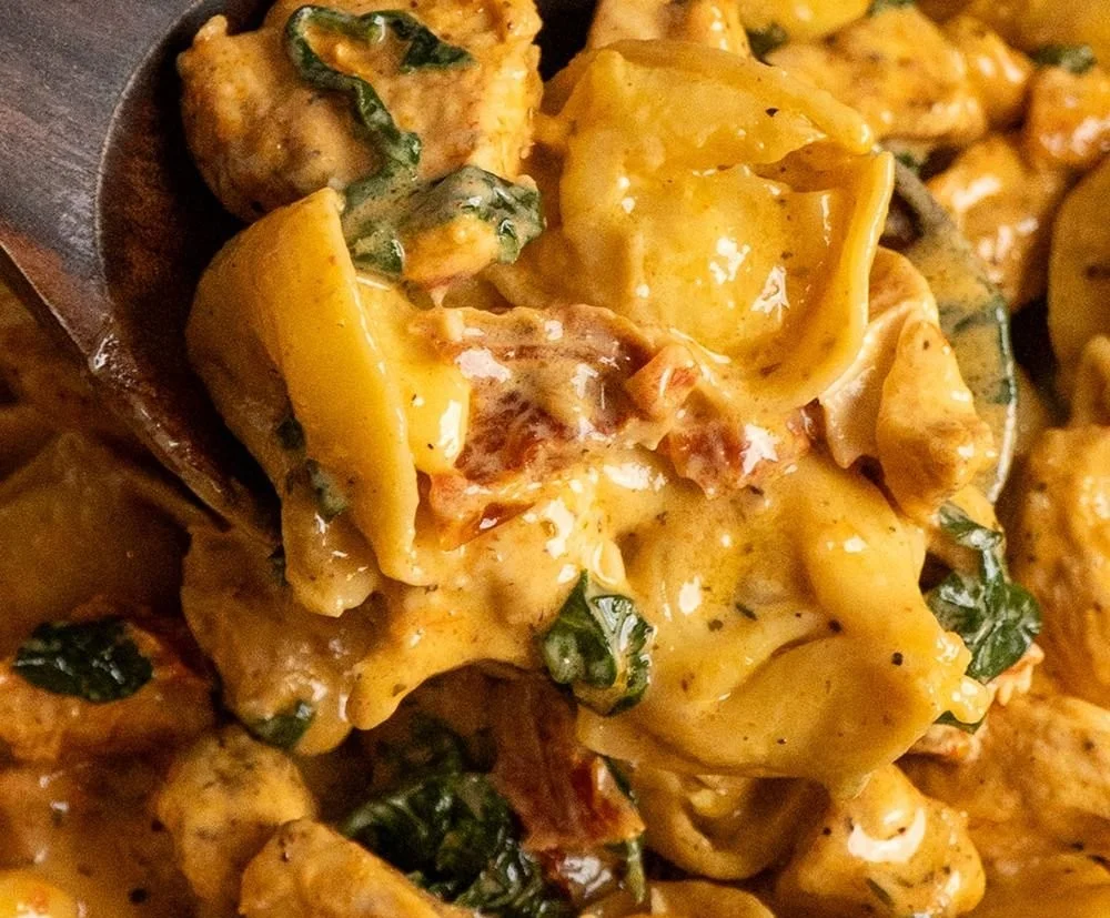 Creamy Marry Me Chicken Tortellini served in a white bowl with herbs on top.