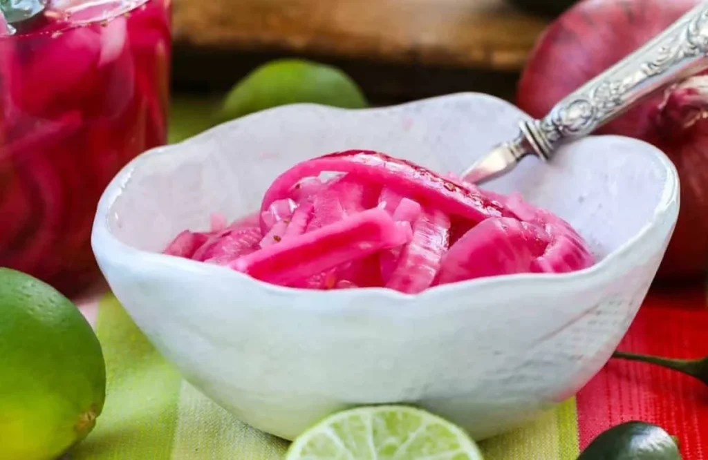 Vibrant Mexican pickled red onions in a jar, perfect for tacos and salads.