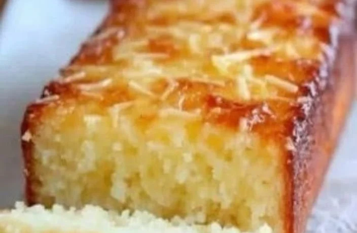Moist gluten-free lemon yogurt cake with no white flour, garnished with lemon zest.