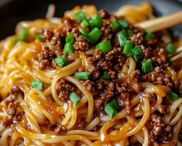 Delicious plate of Mongolian ground beef noodles garnished with scallions.