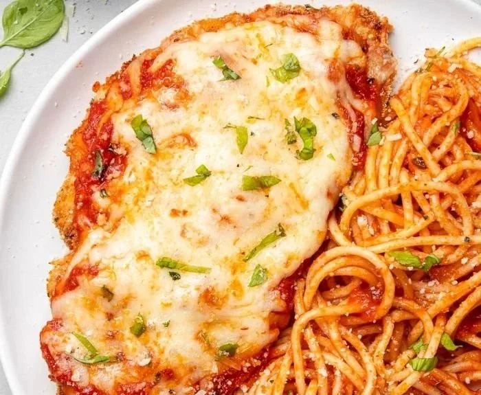 Baked Chicken Parmesan served with marinara sauce and fresh parsley