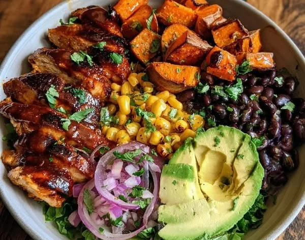 BBQ chicken and sweet potato bowl topped with fresh vegetables