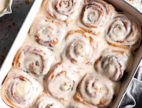 Delicious homemade cinnamon rolls with icing on a wooden table