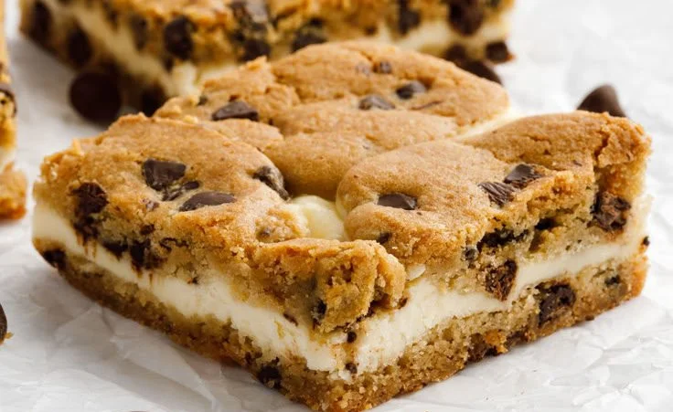 Delicious chocolate chip cheesecake bars served on a white plate