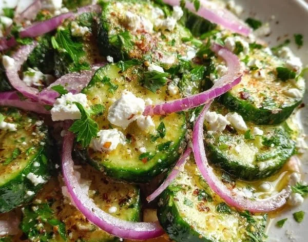 Cucumber feta salad drizzled with lemon Greek vinaigrette, garnished with herbs