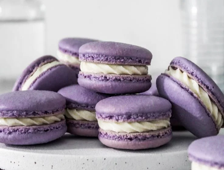 Colorful assortment of homemade French macarons on a white background.