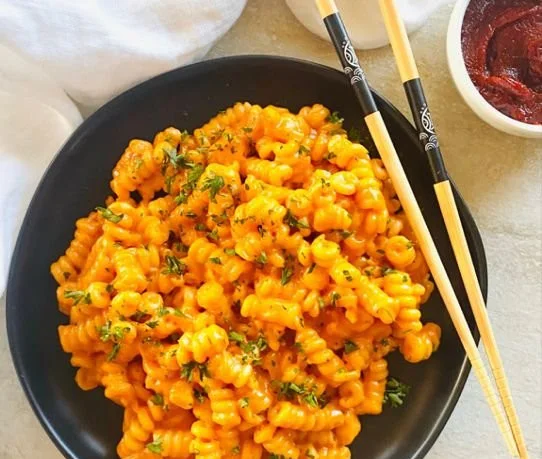 Delicious bowl of Gochujang Pasta garnished with fresh herbs