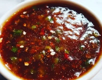 A bowl of homemade dragon sauce with fresh ingredients and spices.