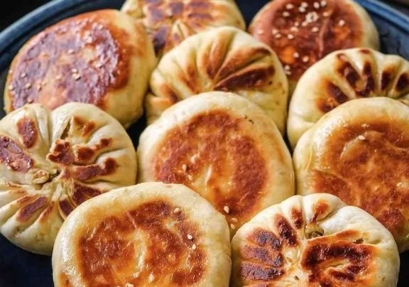 Golden brown pan-fried cabbage and noodle buns on a plate