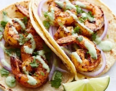 Quick shrimp tacos topped with creamy sauce in a soft tortilla