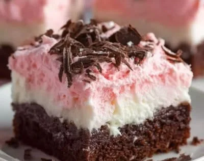 Delicious Sno Ball Brownies on a plate, dusted with powdered sugar