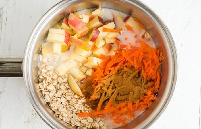 Bowl of Apple Carrot Oatmeal topped with fresh apple slices and shredded carrots