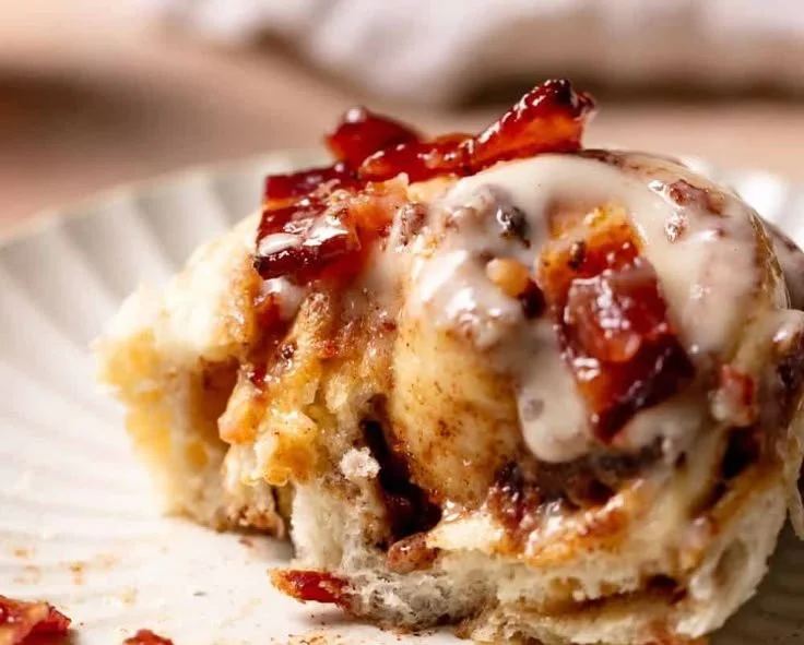 Bourbon Maple Bacon Cinnamon Rolls topped with maple glaze and crispy bacon.