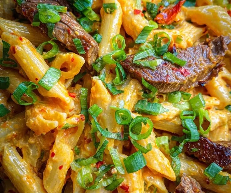 Plate of Buffalo Steak Pasta with bold pepper jack cheese and tender strips