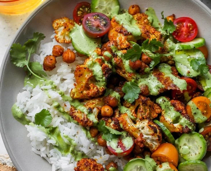 Delicious cauliflower shawarma bowl with fresh vegetables and tahini dressing